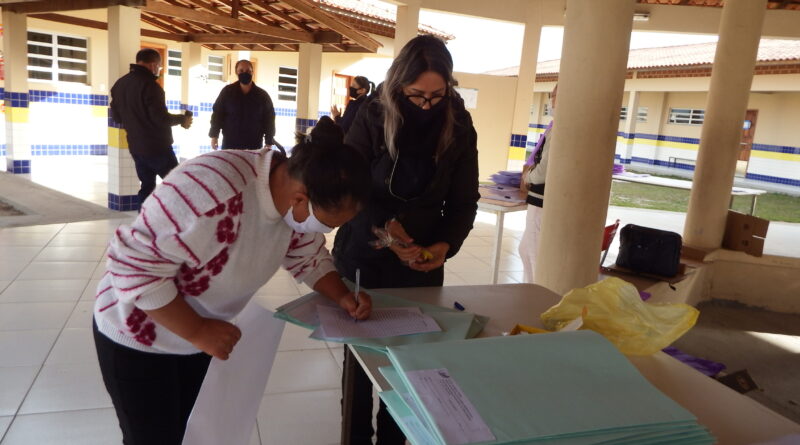 Mãe de aluno recebe apostila na EMEB Luiza Tomasi Scaini